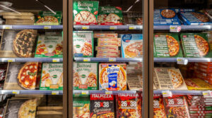 Frozen pizzas and meals stocked inside a micro market freezer, showing how warehouses can provide frozen food options unavailable in vending machines.