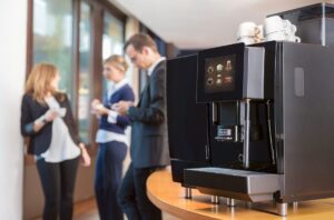 office coffee machine with employees in the background
