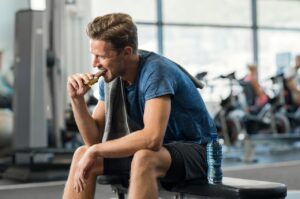 man eating granola bar from a vending